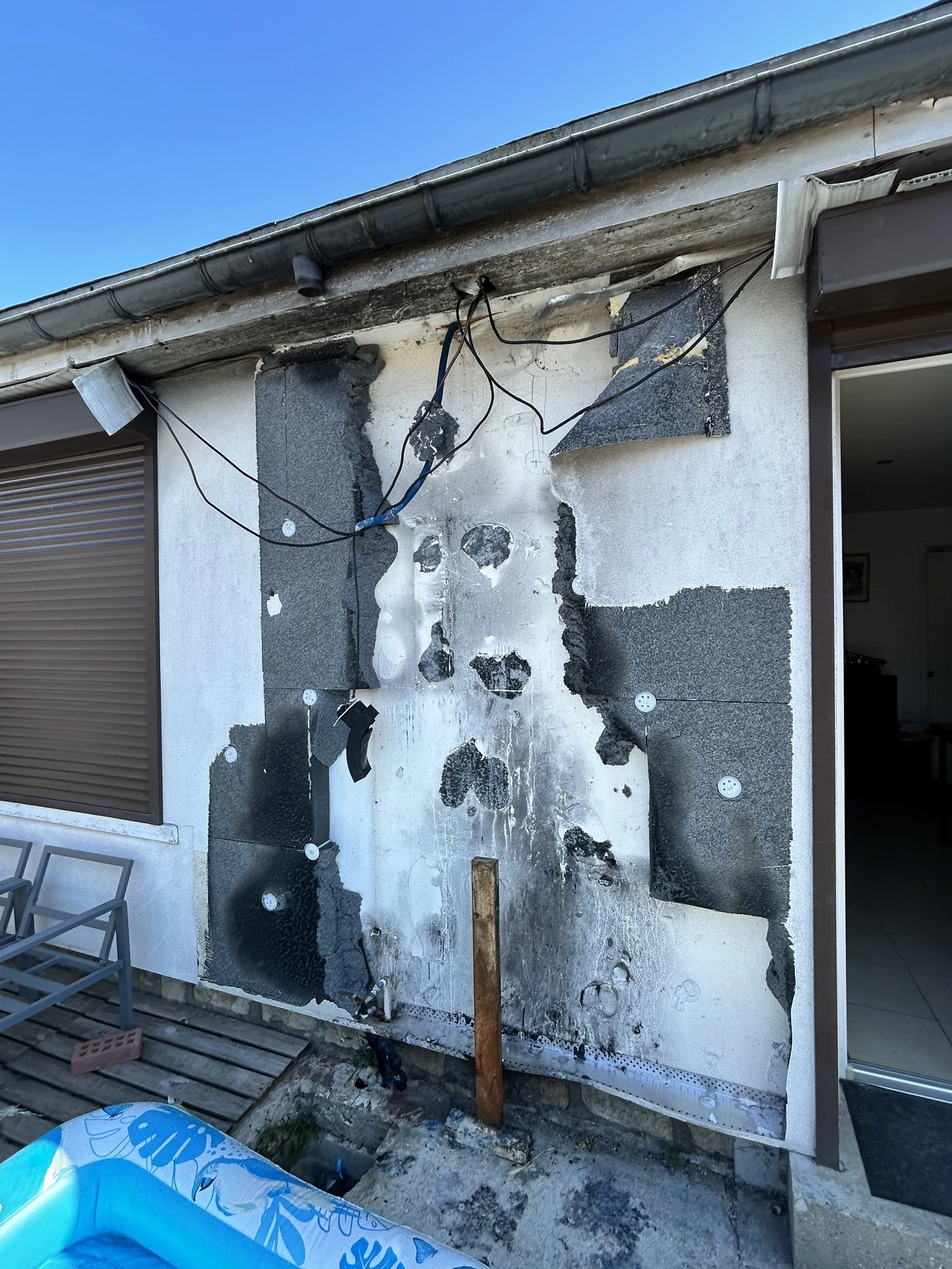 Dépose de l'isolant carbonisé après incendie : rénovation d'une façade sinistrée à Porcheville Dépose de l'isolant carbonisé après incendie : rénovation d'une façade sinistrée à Porcheville