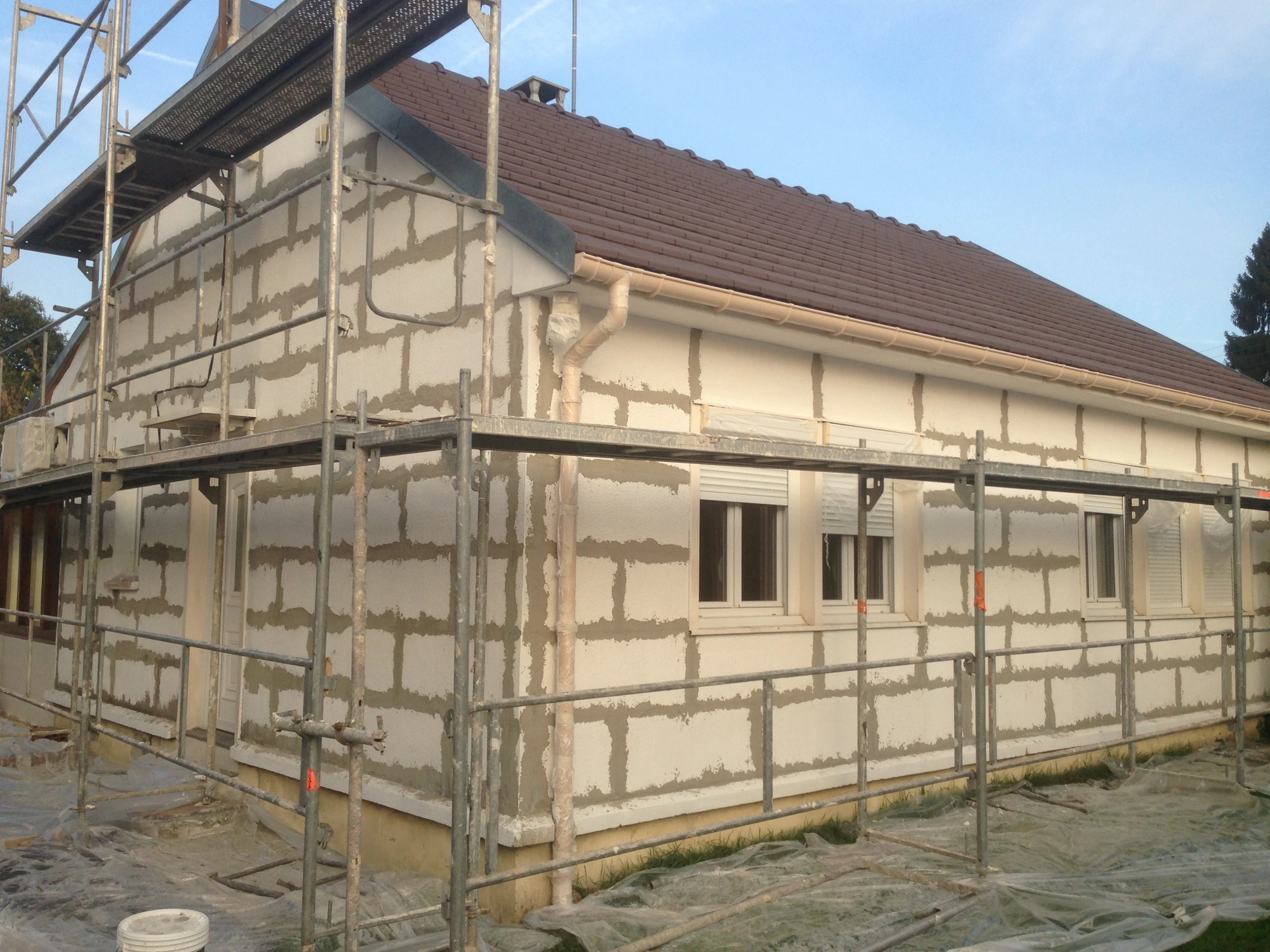 Ragréage total d'une façade de maison préfabriquée à Bois-Colombes, sous échafaudage