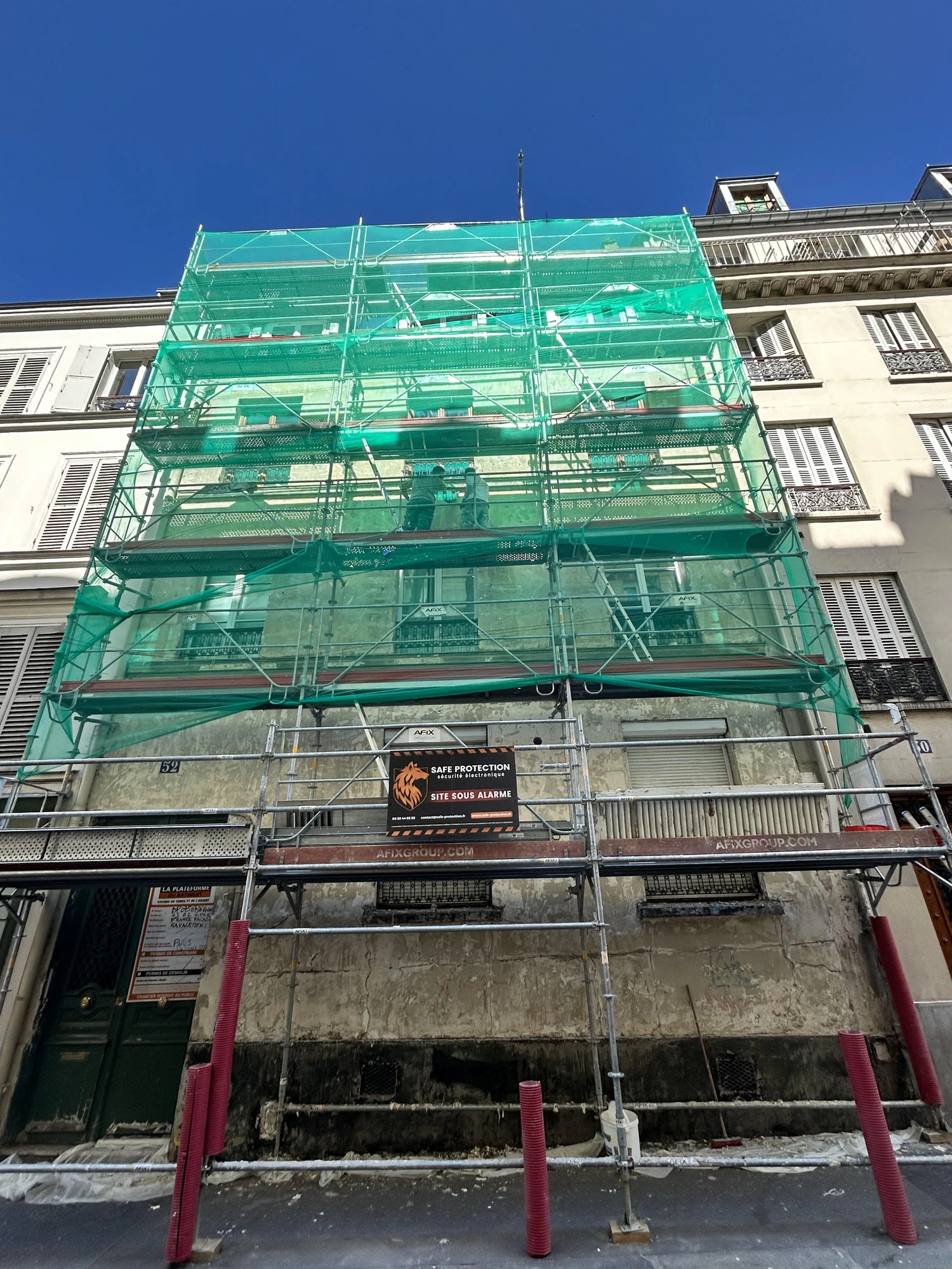 Échafaudage avec filet de protection sur un chantier de ravalement d'immeuble à Paris 17e