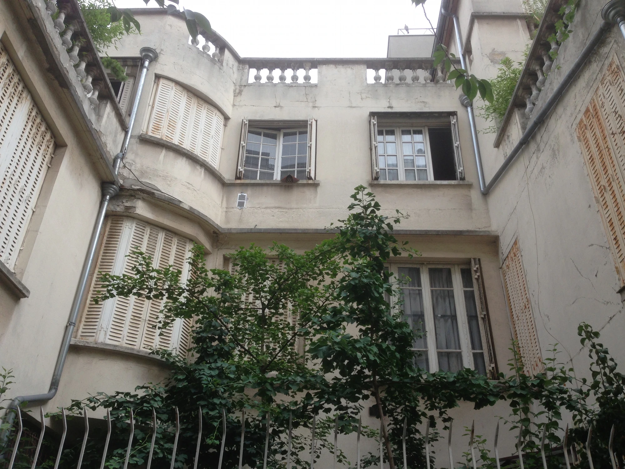 Façade sur cour avant ravalement à Paris 8e : fissures visibles et enduits friables sur maison ancienne Façade sur cour avant ravalement à Paris 8e : fissures visibles et enduits friables sur maison ancienne