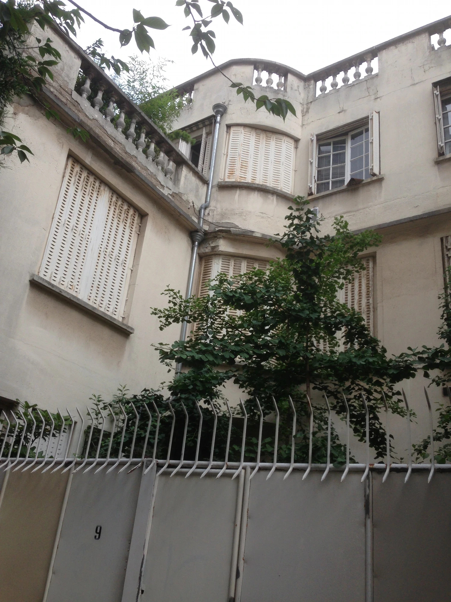 Maison individuelle à Paris 8e avant ravalement : enduit dégradé, fissures et teinte ternie, accès par allée restreinte Maison individuelle à Paris 8e avant ravalement : enduit dégradé, fissures et teinte ternie, accès par allée restreinte