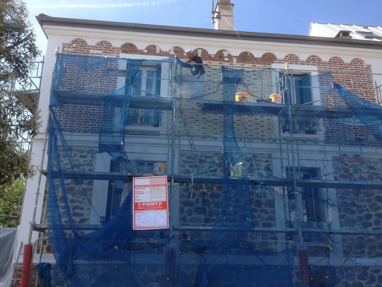 Rejointoiement de façade en pierre depuis l'échafaudage bâché — chantier FRANCE FACADE à Puteaux